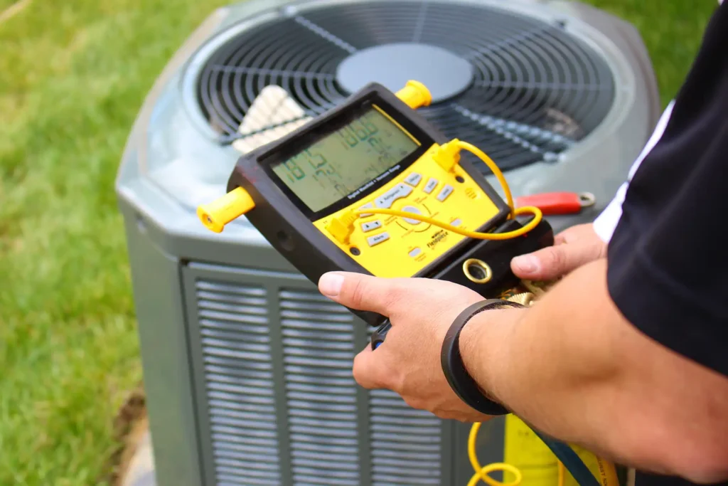 HVAC technician checking refrigerant charge on a new AC system