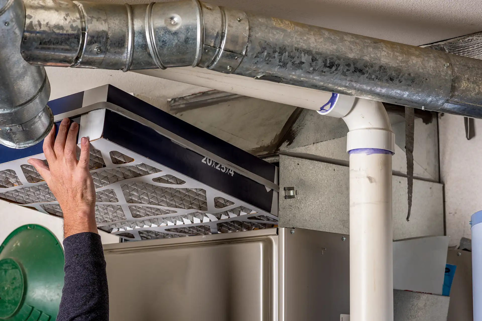 Technician replacing the air filter on a home furnace